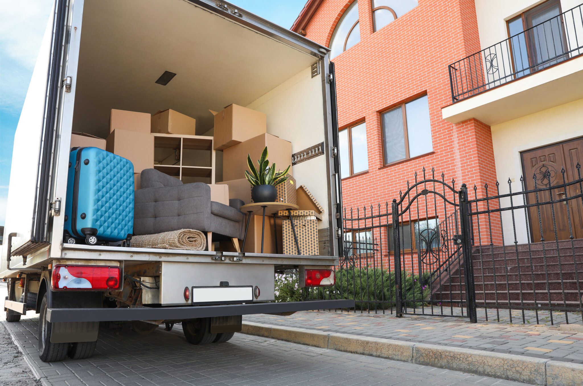 Furniture being loaded into a moving truck outside a residential building.