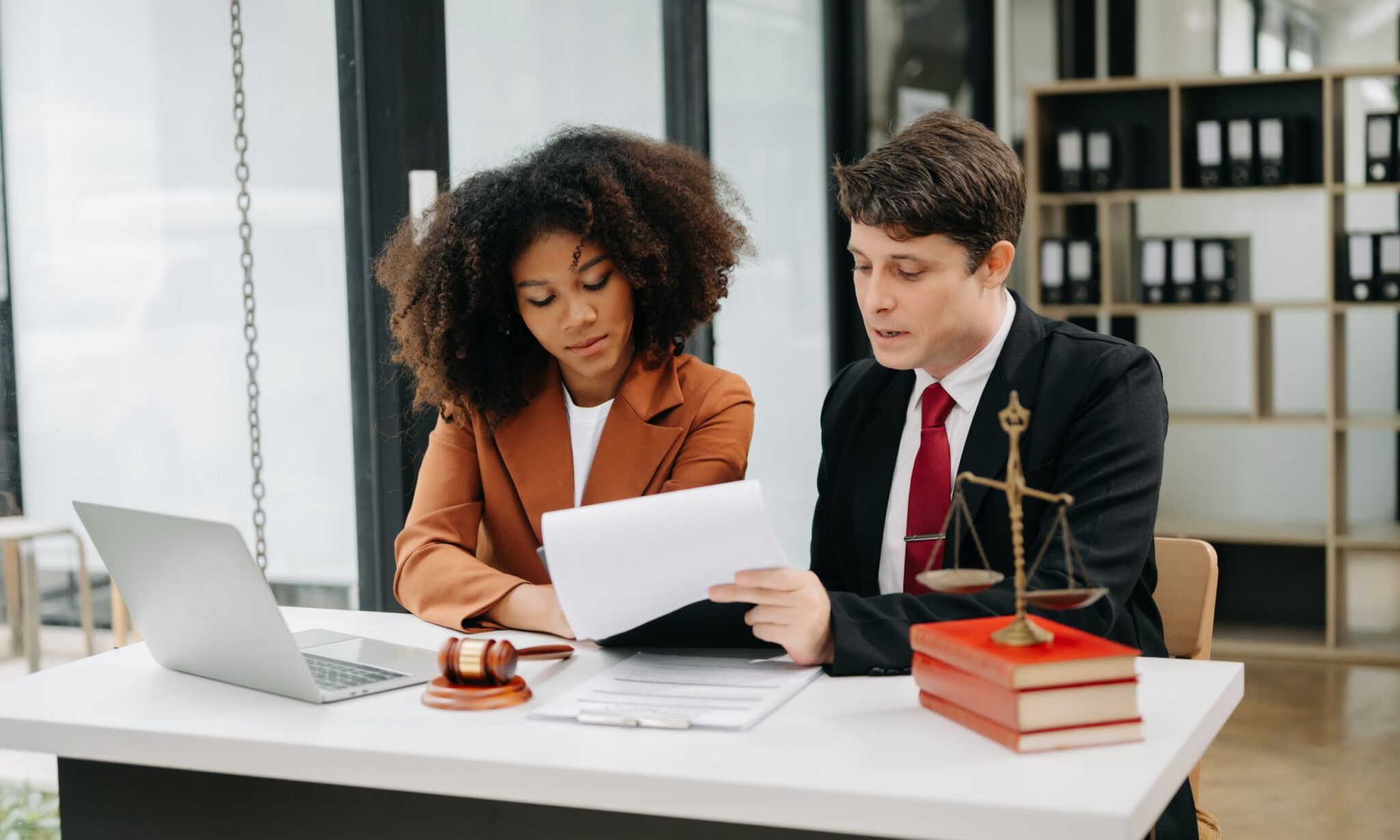 Lawyers discussing documents at an office desk.