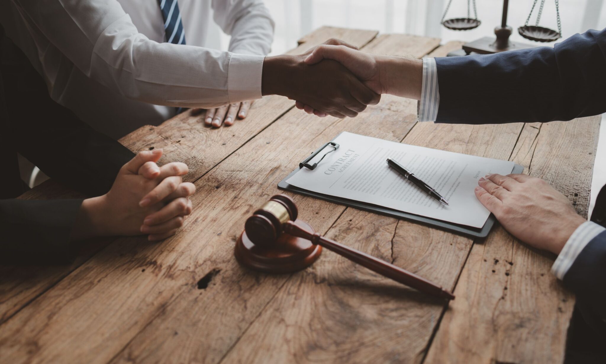 Handshake over legal document and gavel.