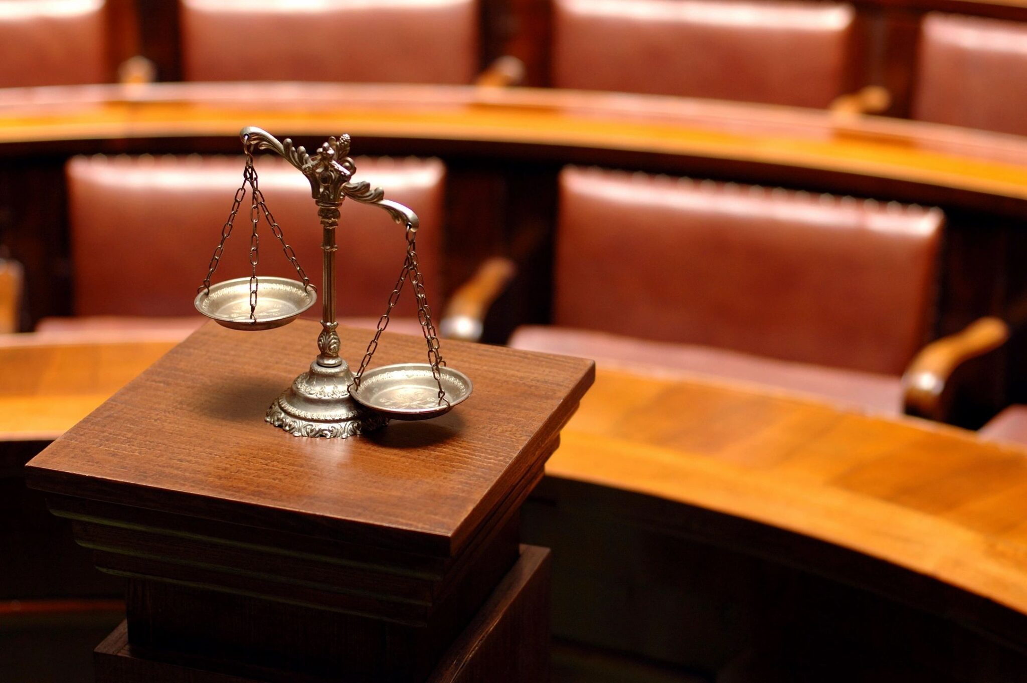Scales of justice in courtroom setting.