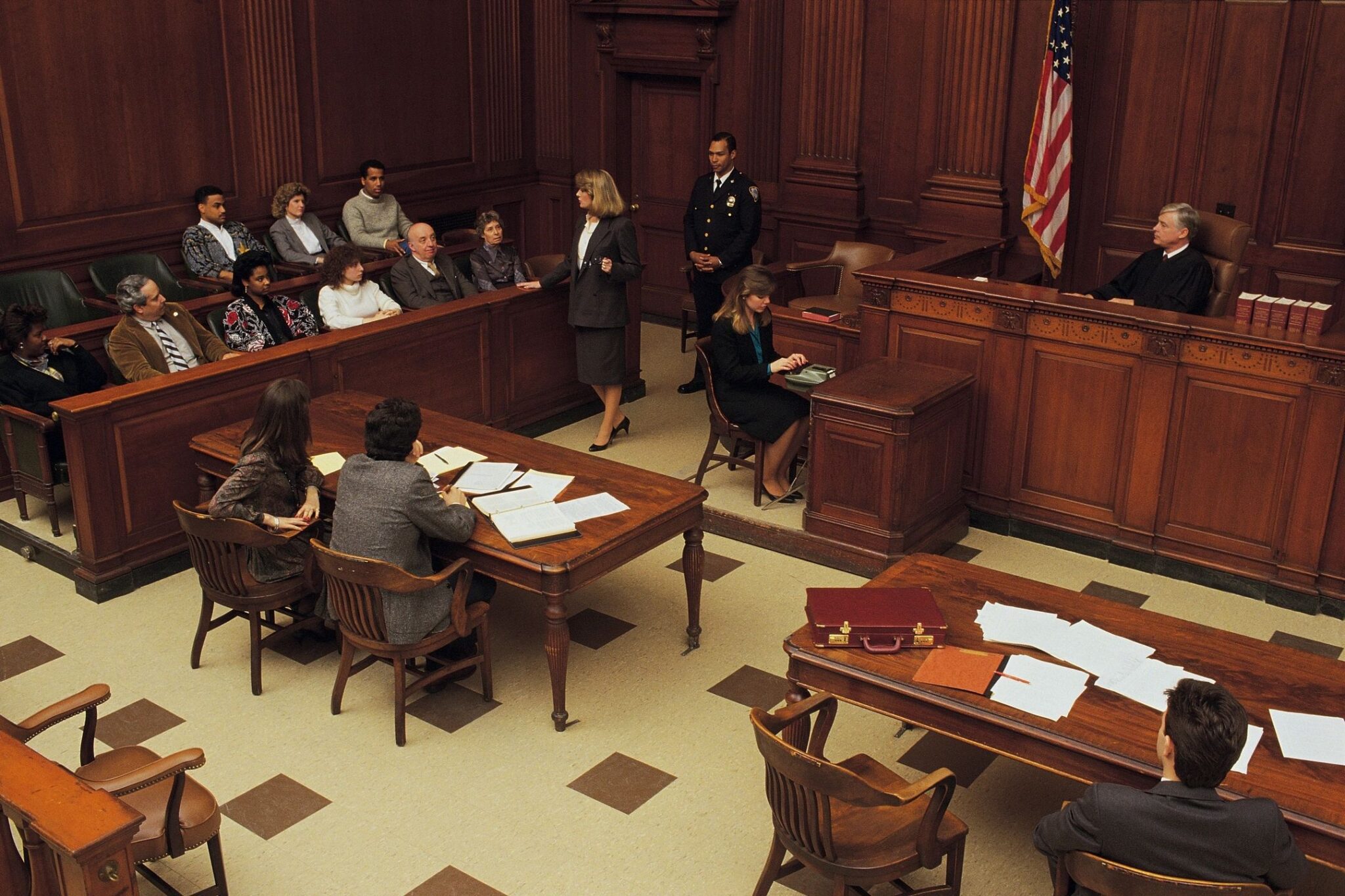 Courtroom scene with judge, lawyers, and jury.