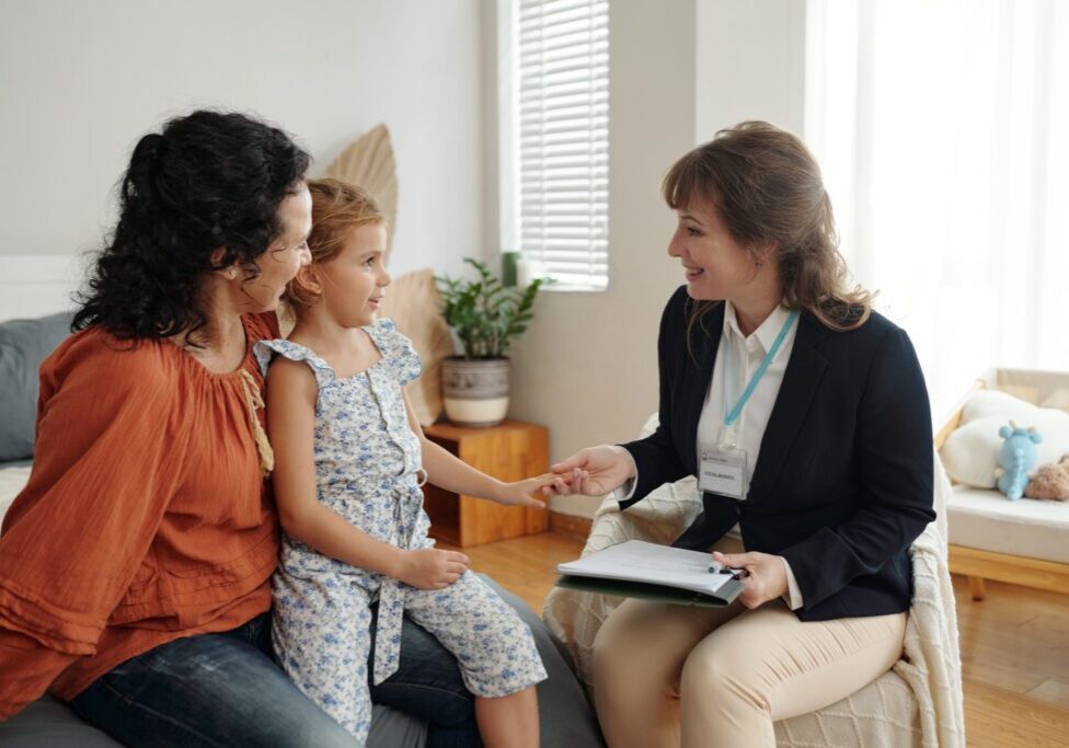 A doctor consulting a mother and her child in a clinic.