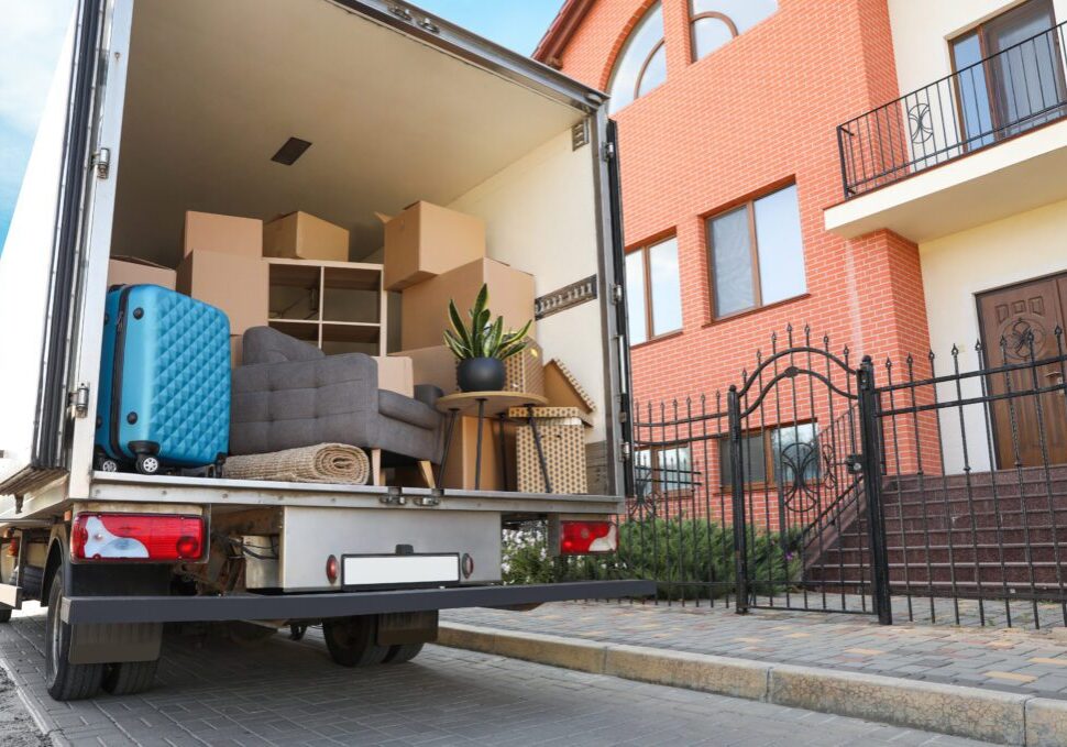 Furniture being loaded into a moving truck outside a residential building.