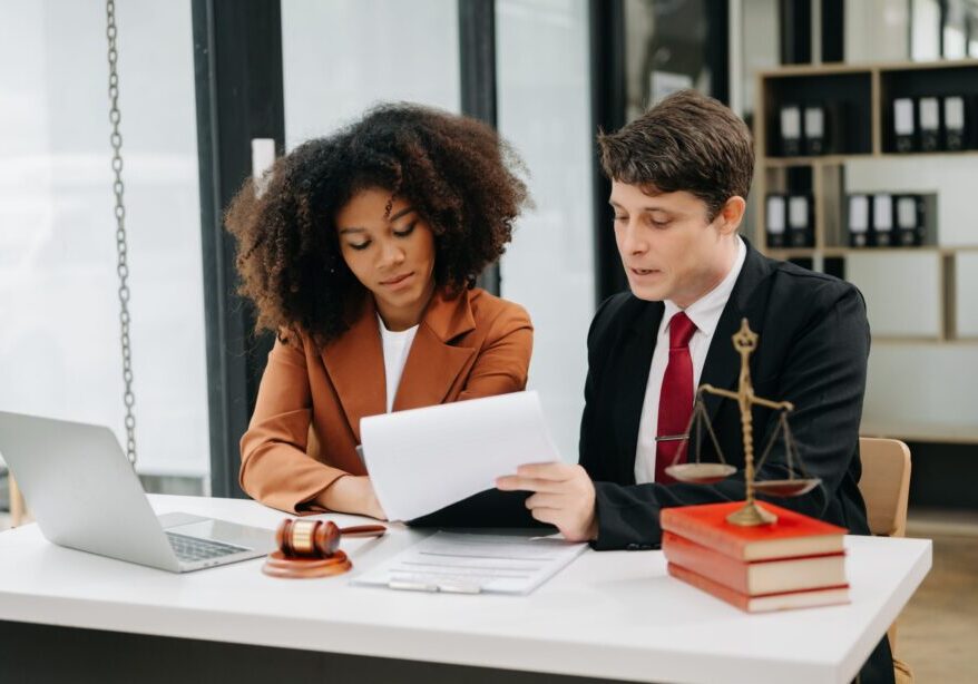 Lawyers discussing documents at an office desk.
