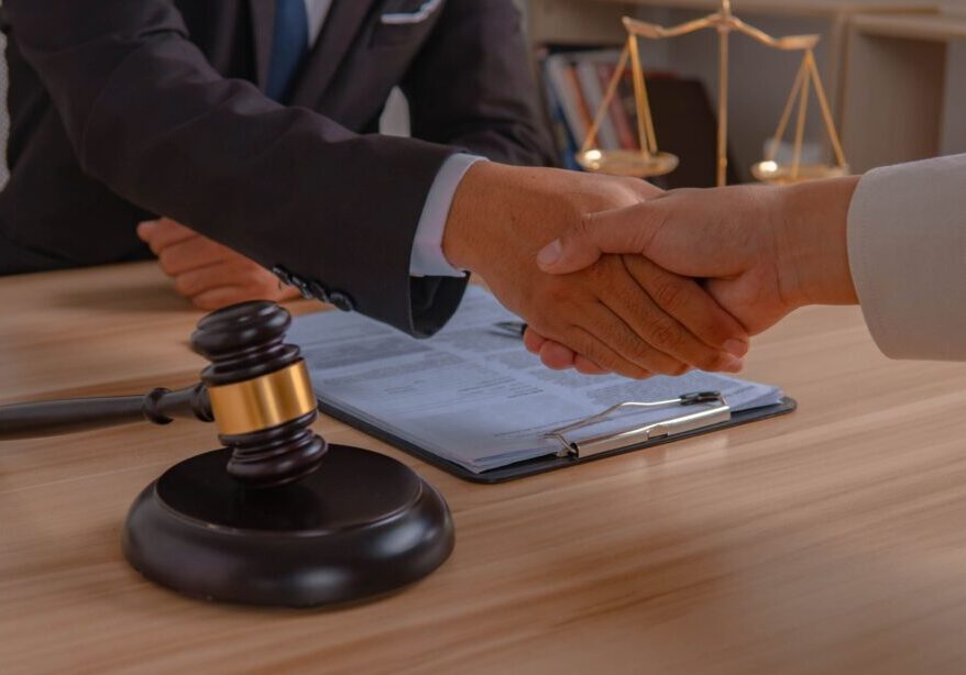 Handshake over legal documents and gavel.