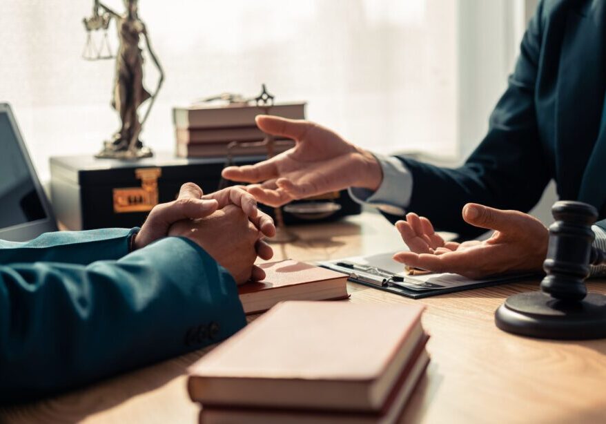 Two people discussing at a lawyer's desk.