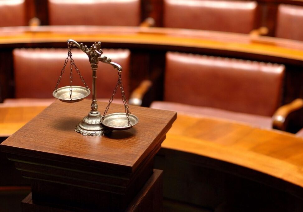 Scales of justice in courtroom setting.