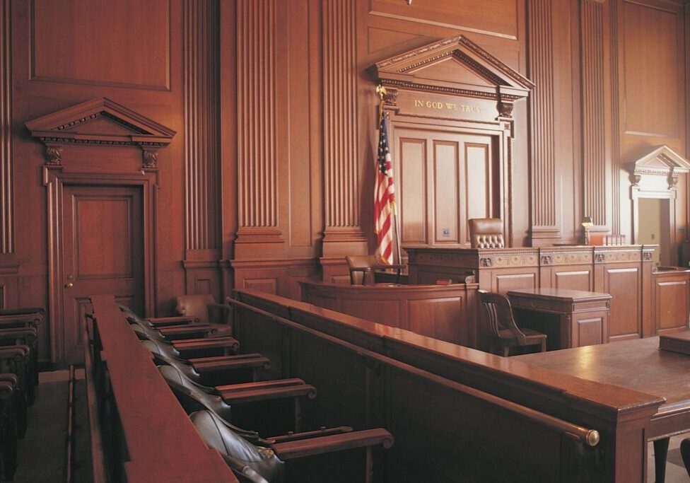 Empty courtroom with wooden interior and flag.