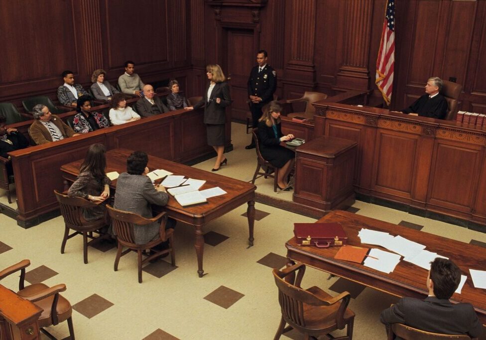 Courtroom scene with judge, lawyers, and jury.