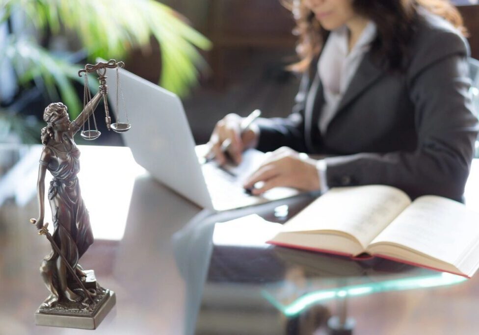 Lawyer working with laptop and legal statue.